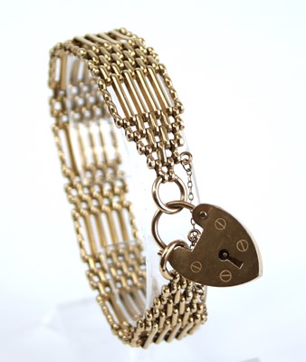 Lot 2401 - A 9ct gold gatelink bracelet, having heart...