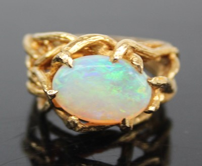 Lot 2459 - An 18ct gold and cabochon opal set dress ring,...