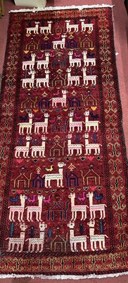 Lot 1172 - A Turkish woollen red ground hall rug, the...