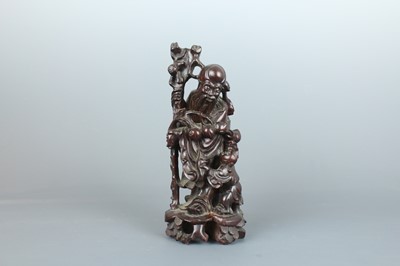 Lot 34 - A Chinese hardwood carving of an immortal...