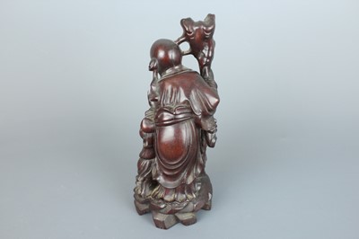 Lot 34 - A Chinese hardwood carving of an immortal...