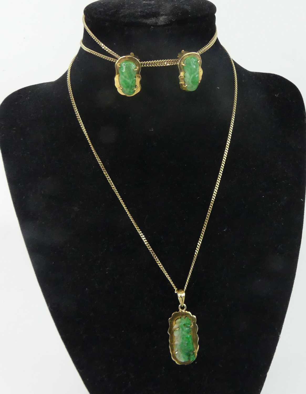 Lot 2586 - A yellow metal carved jadeite pendant and...