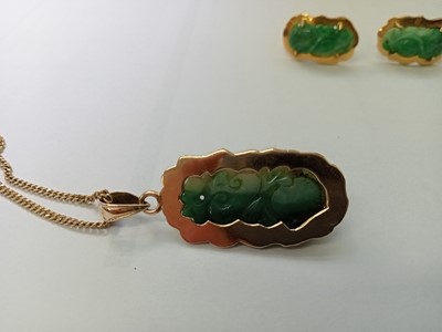 Lot 2586 - A yellow metal carved jadeite pendant and...