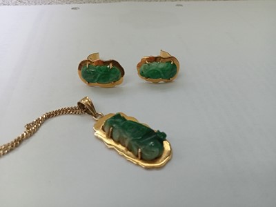 Lot 2586 - A yellow metal carved jadeite pendant and...