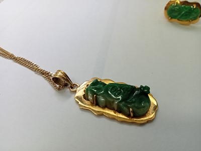 Lot 2586 - A yellow metal carved jadeite pendant and...