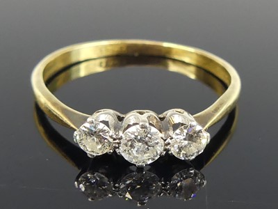 Lot 2745 - An 18ct gold diamond trilogy ring, arranged as...