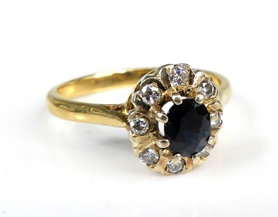 Lot 1154 - An 18ct gold sapphire and diamond oval cluster...
