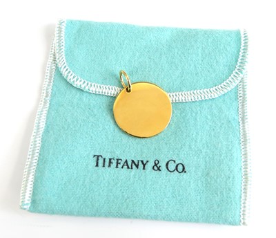 Lot 1196 - A Tiffany & Co 18ct gold disc pendant, being...