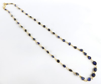 Lot 1171 - A contemporary yellow metal blue sapphire set...