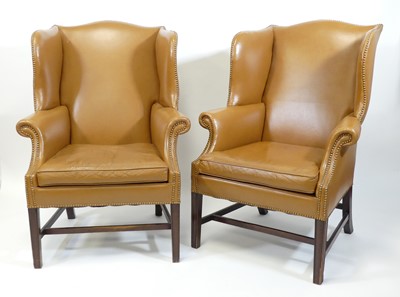 Lot 1412 - A pair of tan leather upholstered wing...