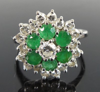 Lot 2558 - A white metal emerald and diamond circular...