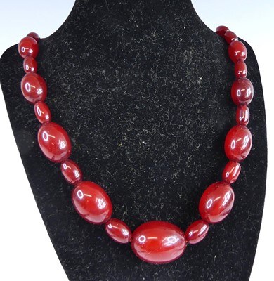 Lot 2561 - A cherry amber necklace arranged as barrel...