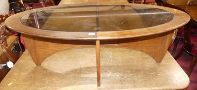 Lot 1237 - A 1960s G-Plan teak and smoky glass inset oval...