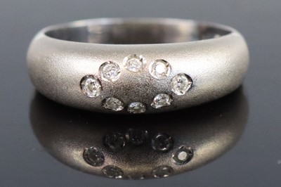 Lot 263 - A contemporary white metal and diamond band...