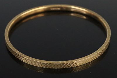 Lot 286 - An engine turned 9ct gold bangle, dia. 7cm, 22.5g