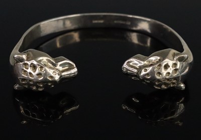 Lot 291 - A modern silver double leopard head bangle,...