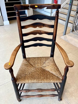 Lot 1346 - An early 20th century oak ladderback rush seat...