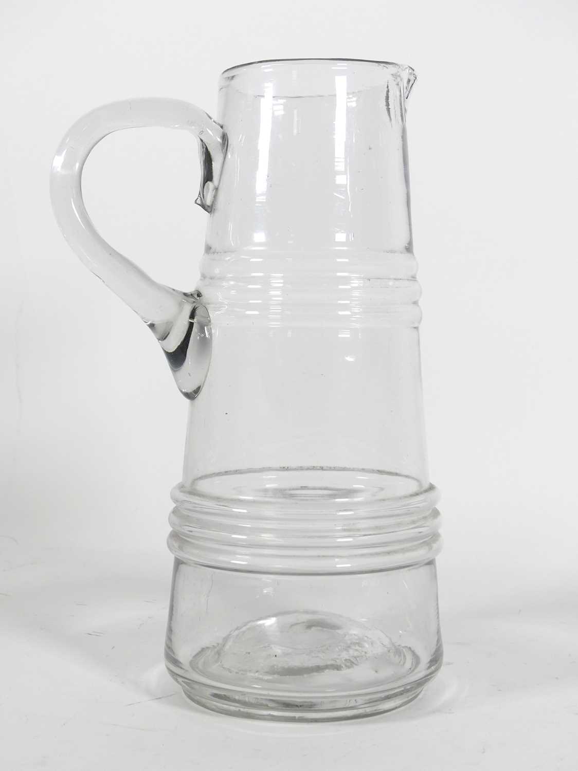 Lot 33 - A hand blown glass jug, of tapered and banded...