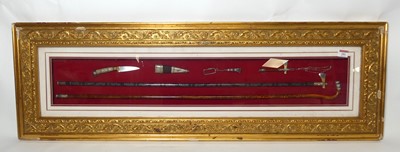 Lot 281 - A framed display of ceremonial items, housed...
