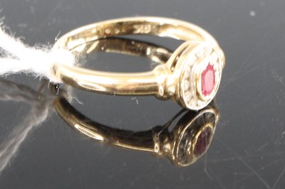 Lot 403 - A yellow metal, ruby and diamond oval cluster...