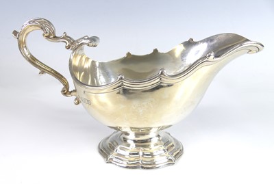 Lot 2137 - A George V silver 'shell' pedestal sauceboat,...