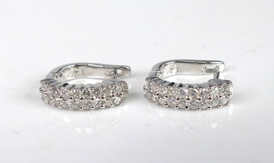 Lot 2183 - A pair of white metal diamond hoop earrings,...