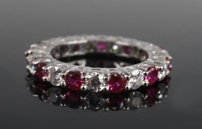 Lot 2171 - A white metal, ruby and diamond eternity ring,...