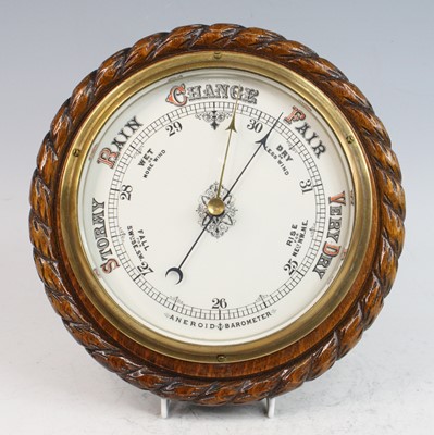 Lot 2389 - An oak cased aneroid wall barometer, having an...