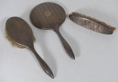 Lot 166 - A George V silver-backed three-piece dressing...