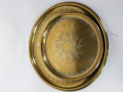 Lot 381 - A graduated pair of Indian brass trays, each...