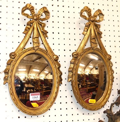 Lot 1163 - A pair of small gilt floral framed oval convex...