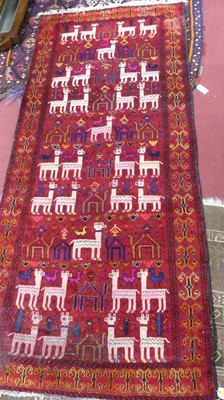 Lot 1414 - An Afghan red ground woollen Baluchi pictorial...