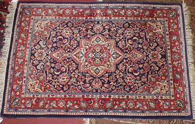 Lot 1415 - A Persian woollen red, blue, and cream ground...