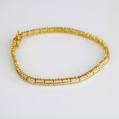 Lot 333 - A yellow metal tennis bracelet, set with 216 1....