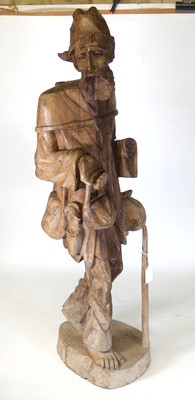 Lot 201 - An eastern carved softwood figure of a peasant...
