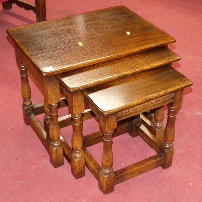 Lot 543 - A reproduction joined oak nest of three...