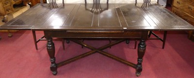 Lot 605 - An oak draw-leaf dining table, early 20th...