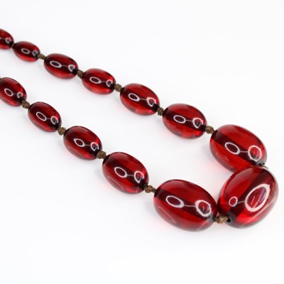 Lot 356 - A faux cherry amber necklace arranged as...