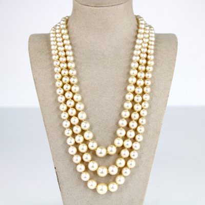 Lot 2174 - A three-row pearl necklace featuring 49, 56...
