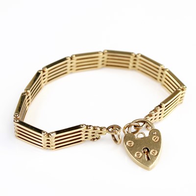 Lot 2113 - A 9ct gold gatelink bracelet, having a heart...