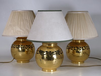 Lot 5 - A set of three hammered brass table lamps,...