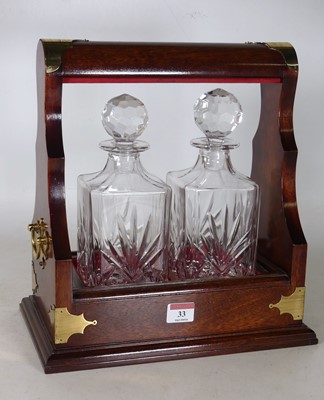 Lot 33 - A reproduction hardwood two-decanter tantalus,...