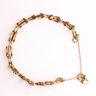 Lot 375 - A 9ct gold gate link bracelet with heart...