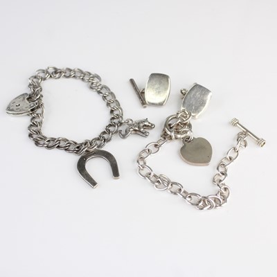 Lot 403 - A silver curb link bracelet containing two...