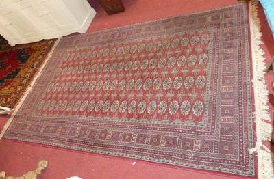 Lot 714 - A Persian woollen red ground Bokhara rug, 250...
