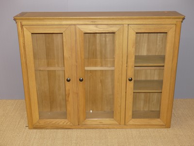 Lot 763 - A ontemporary blond oak three door glazed...