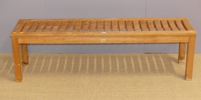Lot 631 - A contemporary slatted teak long patio bench,...