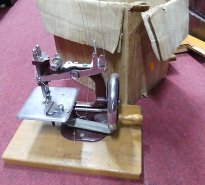 Lot 192 - A child's sewing machine, on a wooden base,...