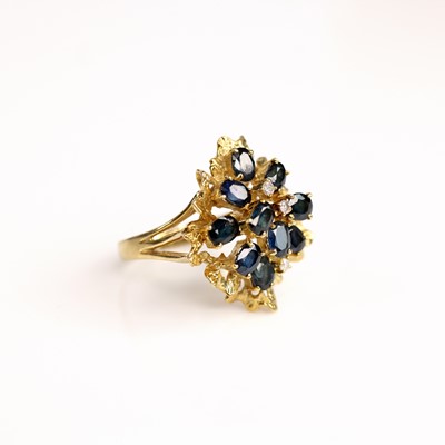 Lot 240 - A yellow metal, sapphire and diamond abstract...