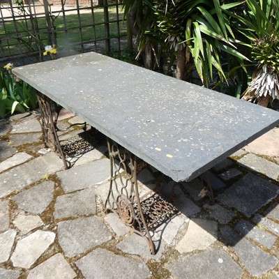 Lot 582 - A garden table as a slate slab upon two Singer...